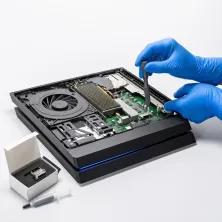 Reparar PS4 Fat en Madrid: técnico con guantes azules abriendo la consola