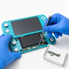 Reparar Nintendo Switch Lite en Madrid: técnico con guantes azules abriendo la consola